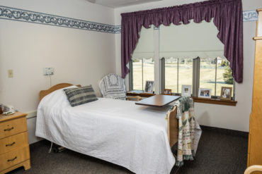 Single bed in a skilled nursing room with a dresser